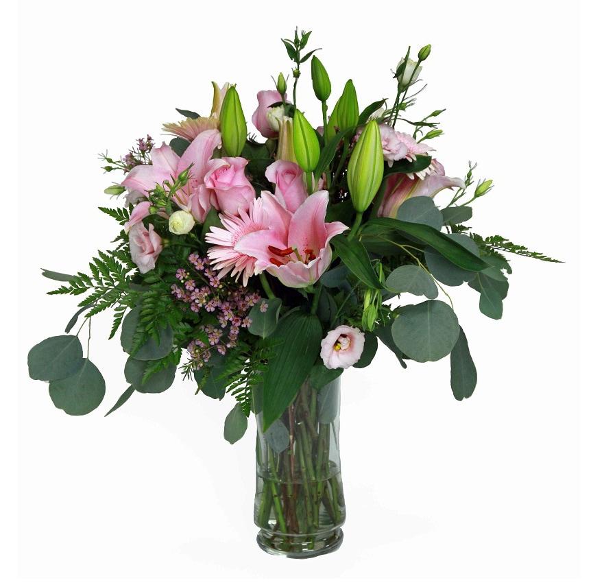 A vase arrangement with pink roses, lilies, mini gerberas, greens and fillers.