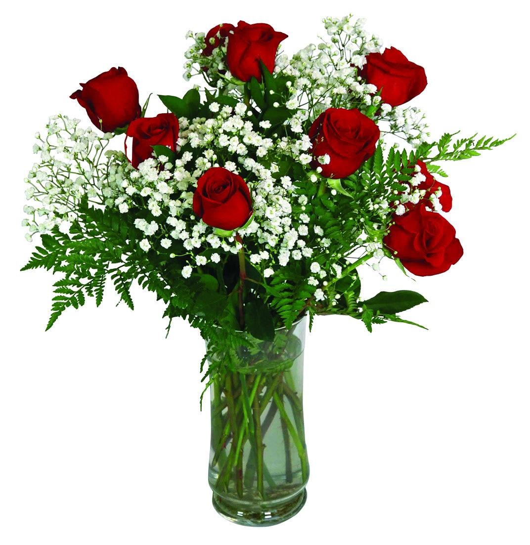 A dozen long stemmed red roses with greens and baby's breath in a vase.